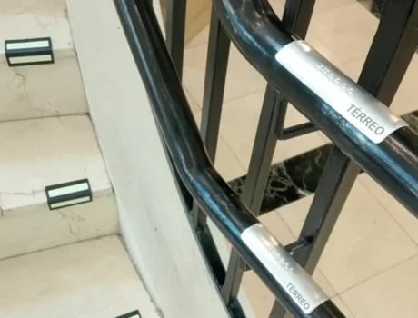 faixa verse e placa braile de corrimão na escada